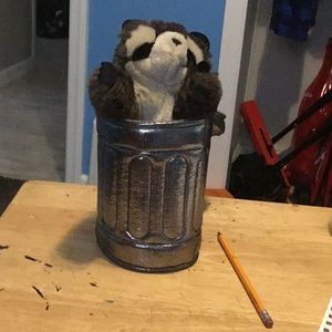 racoon puppet inside a trashcan